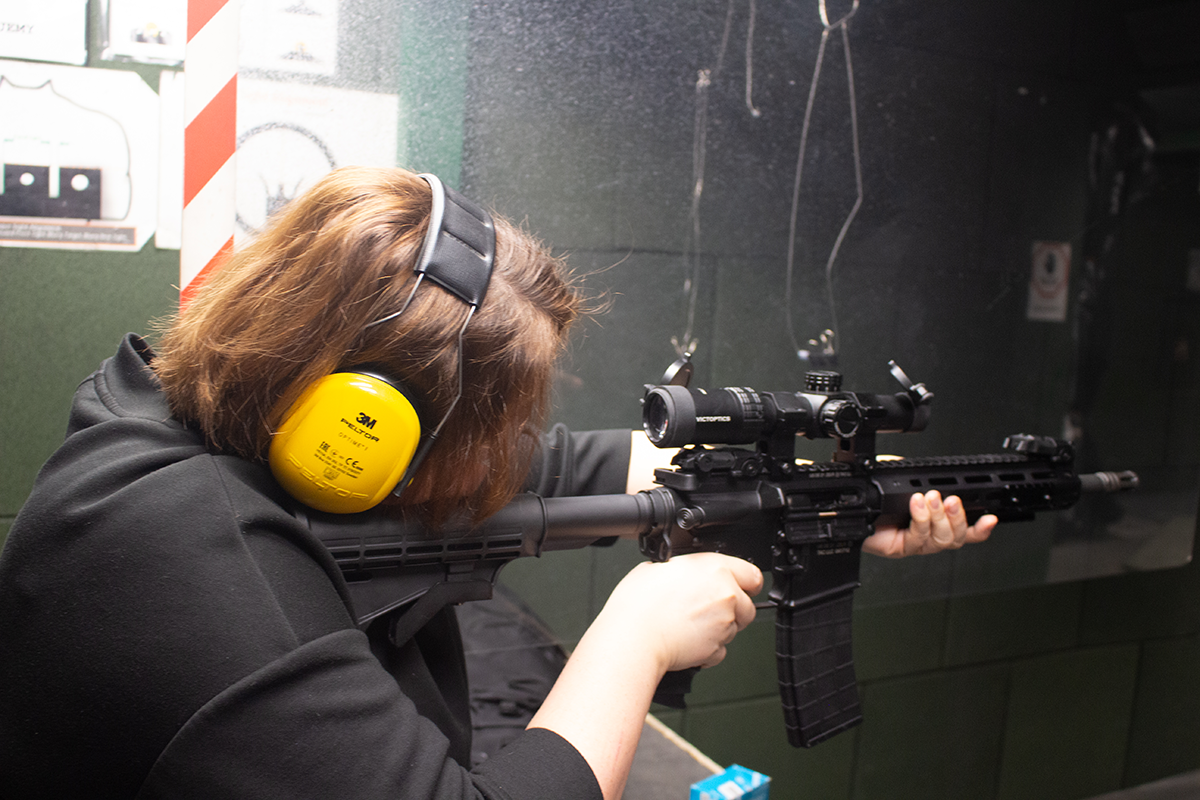 Kobieta strzelająca z broni na strzelnicy zamkniętej